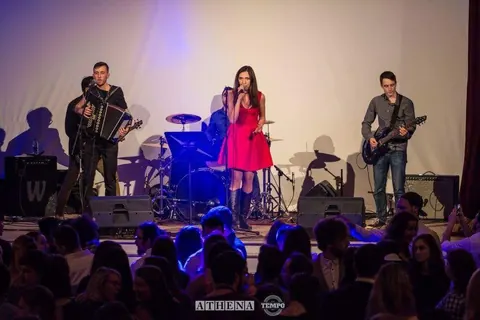 A packed room in front of the stage, the singer in a red dress